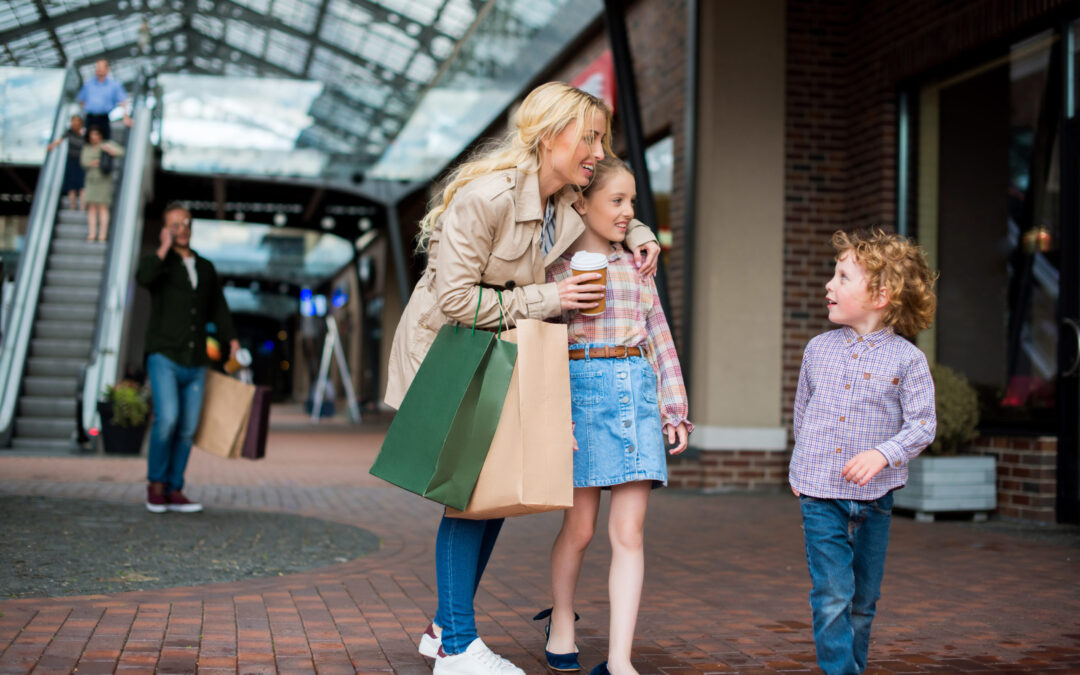 young mother talking with her little kids during shopping at shopping centre